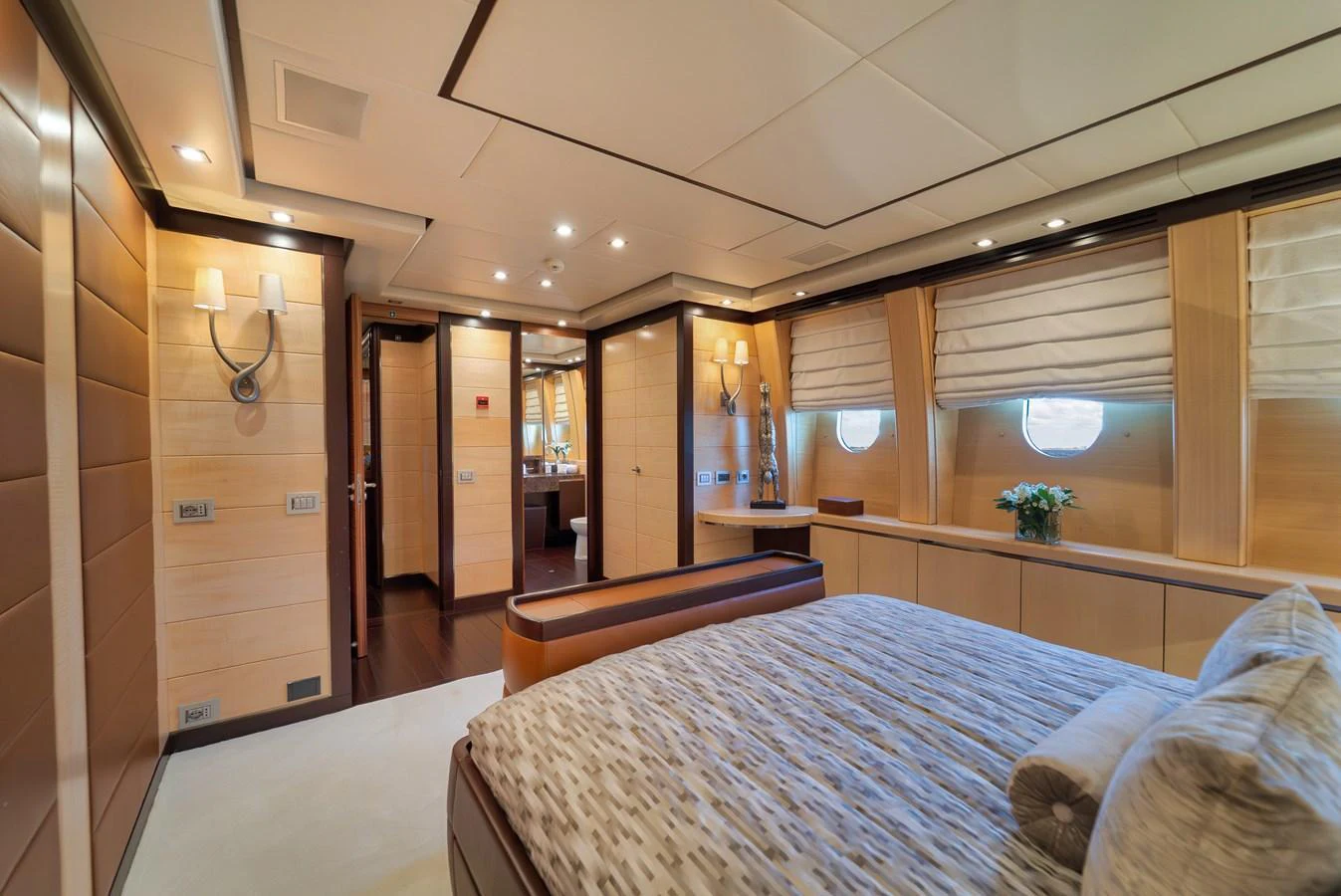 The master stateroom features luxurious wood paneling, ample natural light, and elegant decor. aboard BET ON IT Yacht for Sale