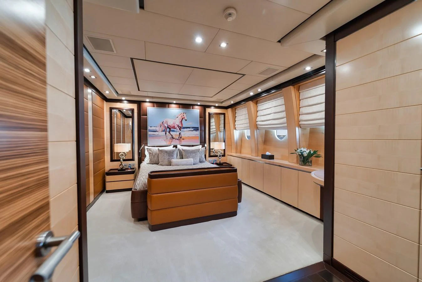 The master stateroom features a luxurious bed, elegant wood paneling, and tasteful decor. aboard BET ON IT Yacht for Sale