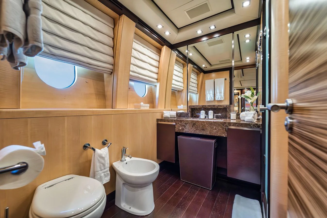 The yacht's bathroom features elegant wood paneling and modern fixtures, creating a luxurious and comfortable space. aboard BET ON IT Yacht for Sale