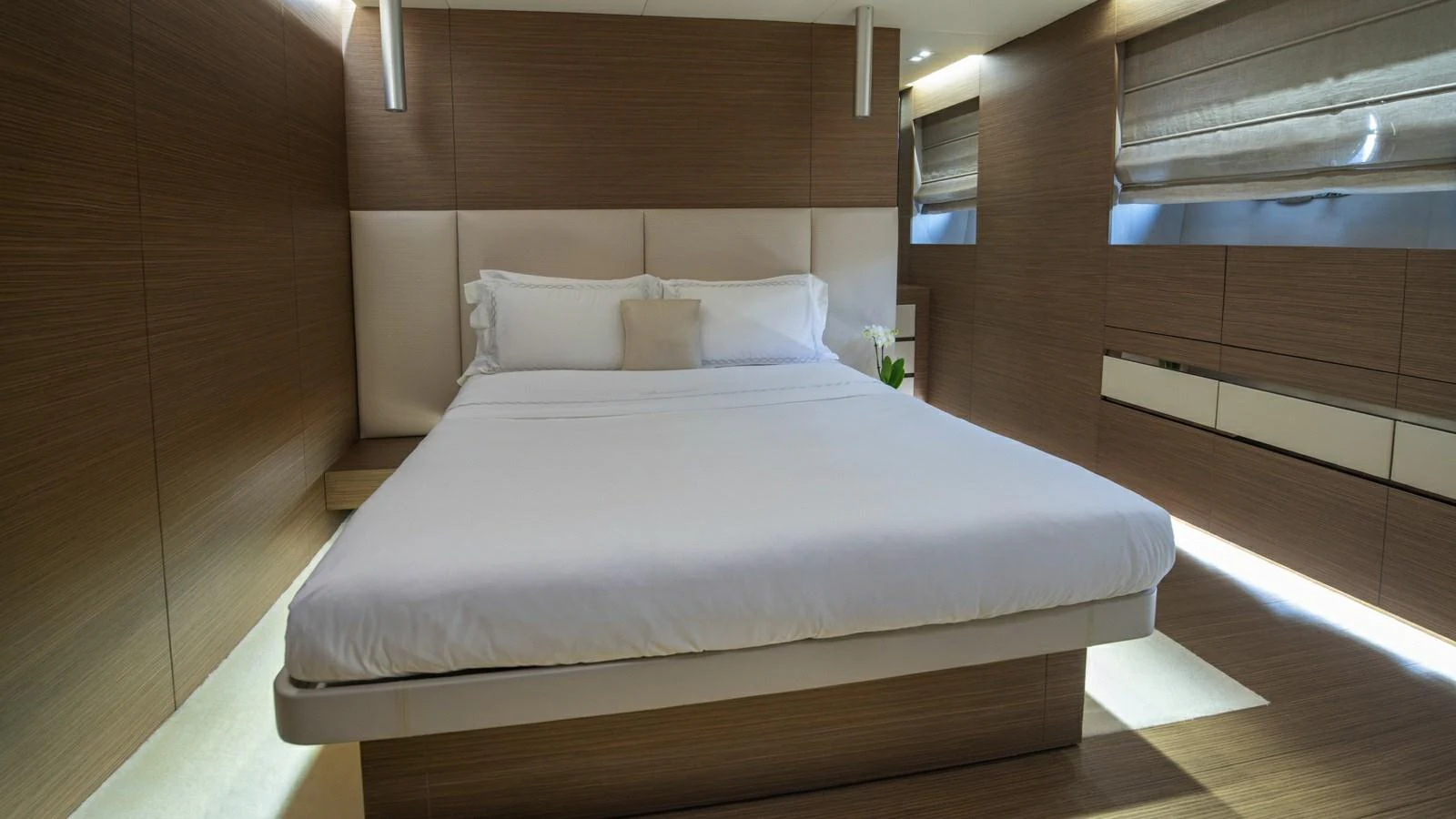 The stateroom features a modern design with warm wood tones and soft lighting. aboard IPANEMAS Yacht for Sale