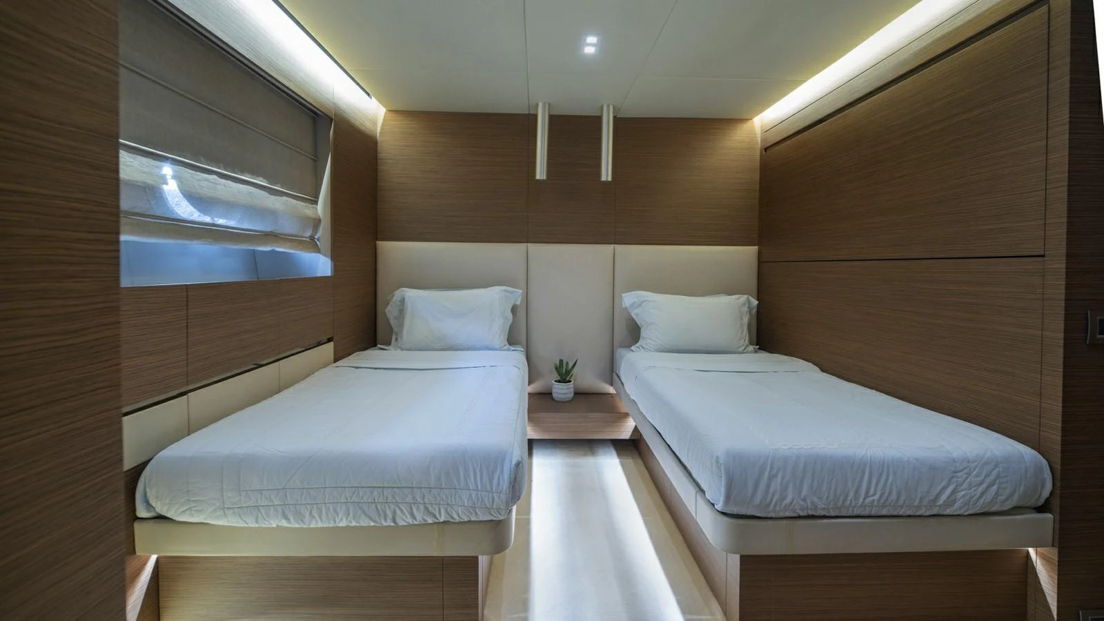 The twin stateroom features modern design with two single beds and ambient lighting. aboard IPANEMAS Yacht for Sale