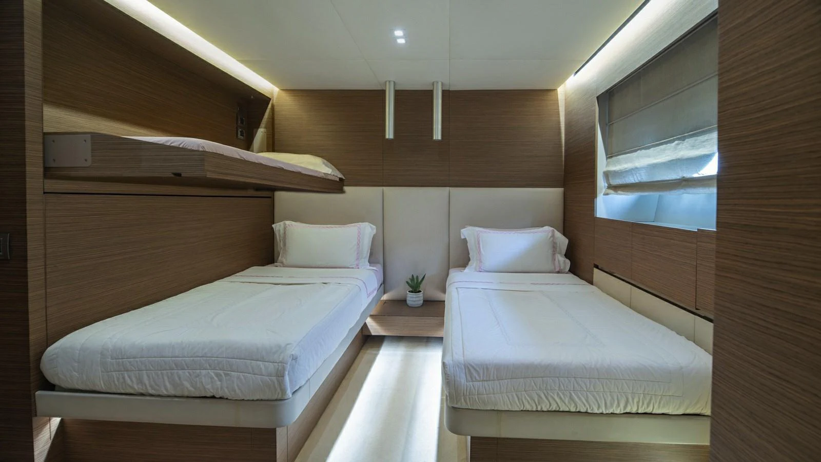 A cozy guest stateroom with twin beds and modern wooden finishes. aboard IPANEMAS Yacht for Sale