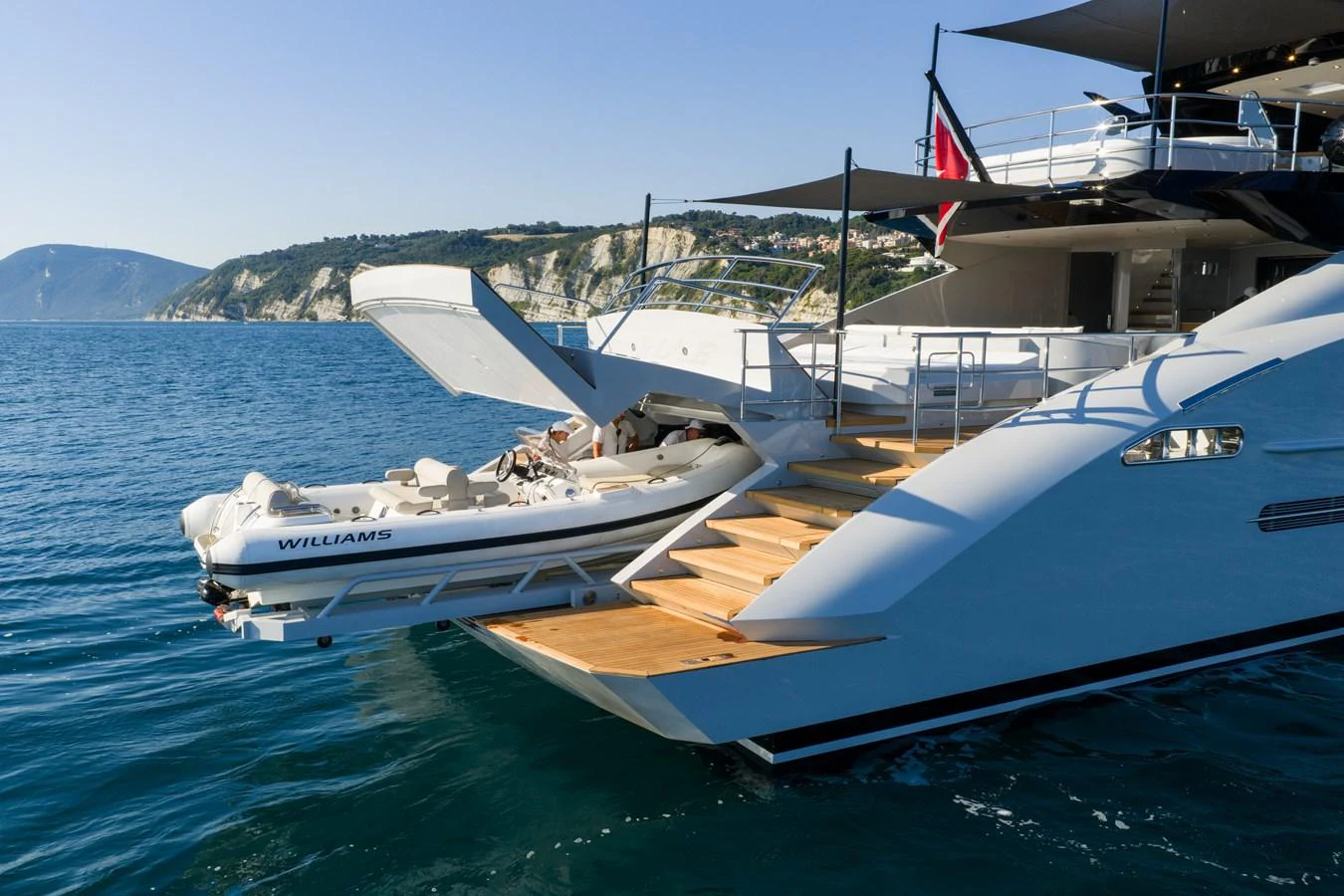 The yacht's aft deck features a tender garage with a tender ready for launch. aboard FIVE Yacht for Sale