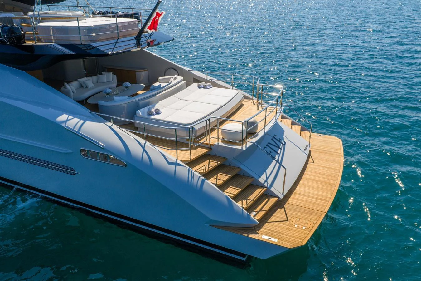 The yacht's aft deck features a spacious lounging area with direct access to the water. aboard FIVE Yacht for Sale