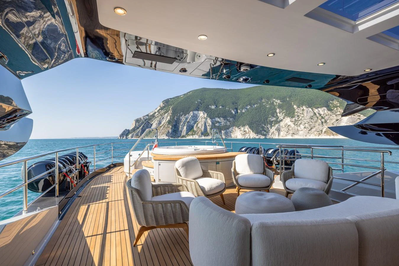 The aft deck offers a luxurious seating area with stunning ocean and mountain views. aboard FIVE Yacht for Sale