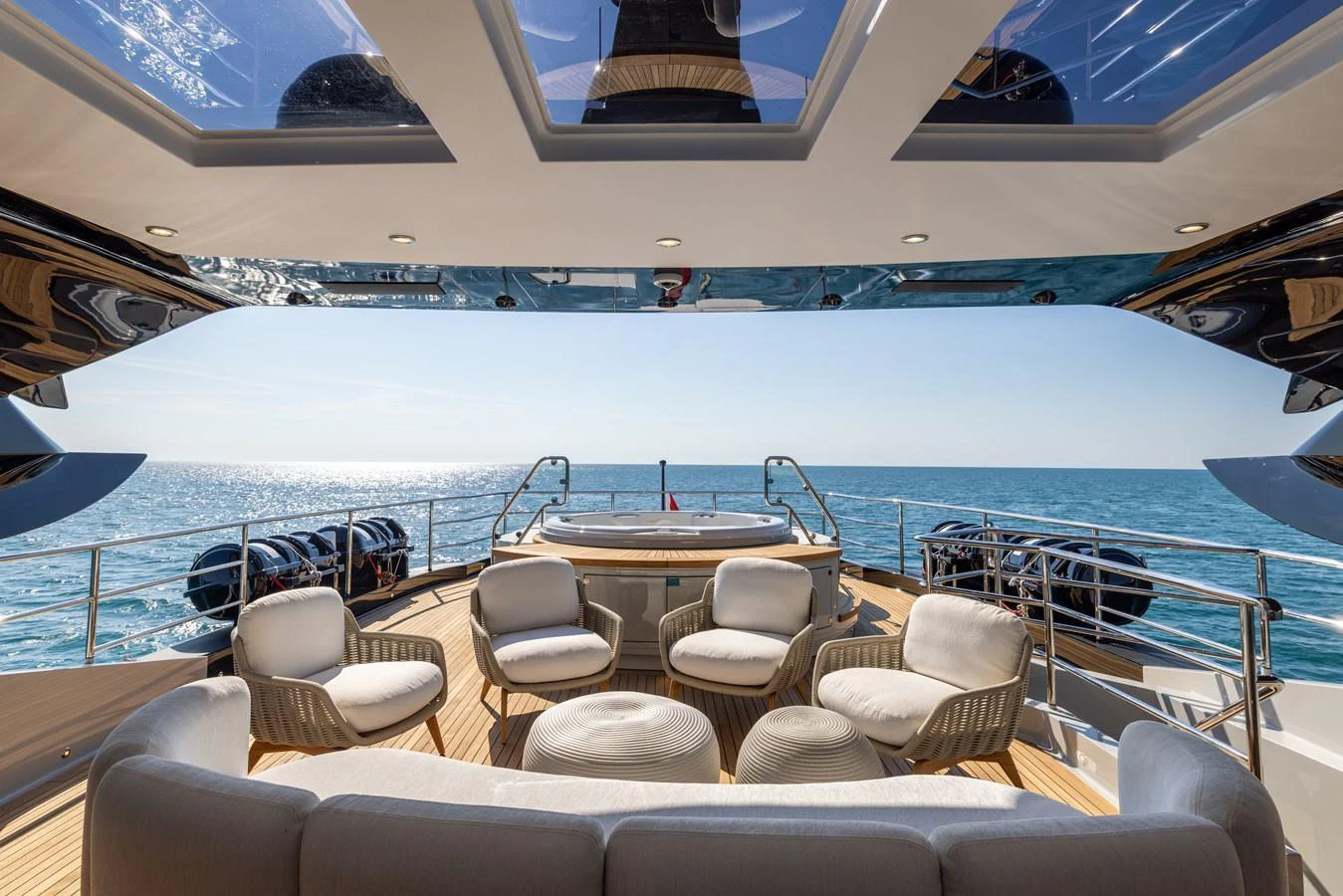 The aft deck features a luxurious seating area with a jacuzzi, offering stunning ocean views. aboard FIVE Yacht for Sale