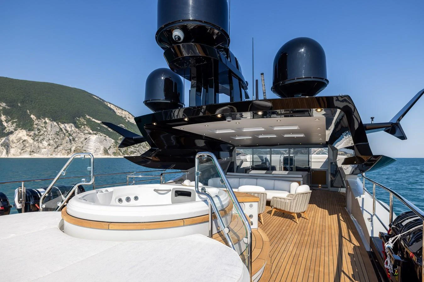 The sundeck features a luxurious jacuzzi and ample seating with a stunning ocean backdrop. aboard FIVE Yacht for Sale