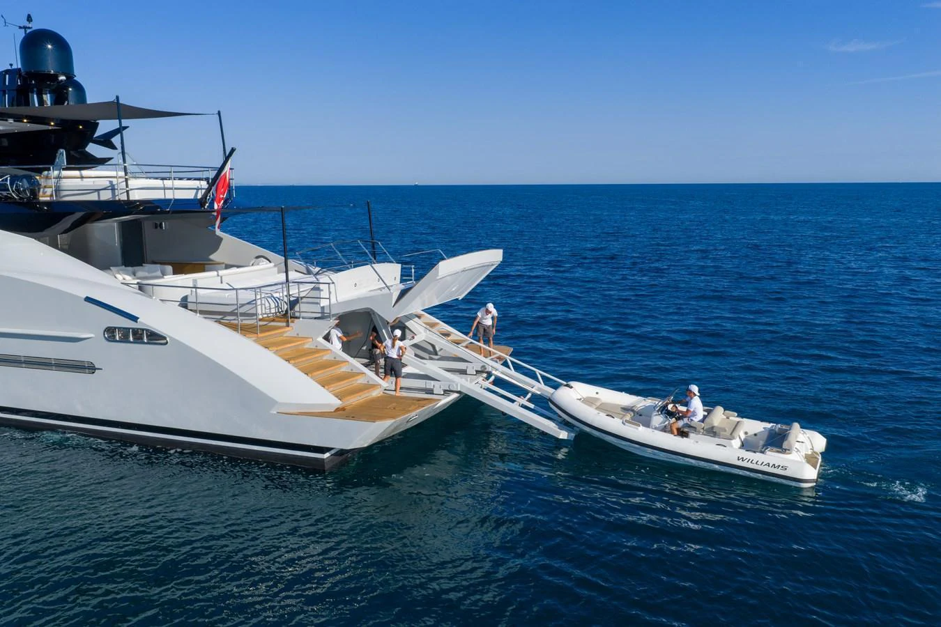 A sleek yacht with a tender boat docked alongside in the open sea. aboard FIVE Yacht for Sale