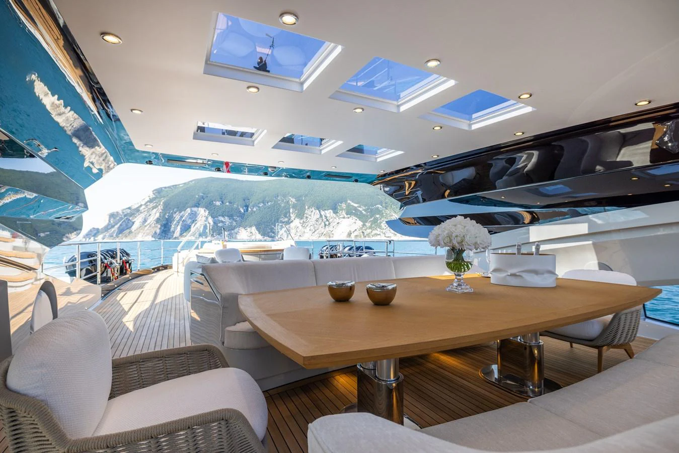 The aft deck features a spacious dining area with stunning views of the surrounding waters. aboard FIVE Yacht for Sale