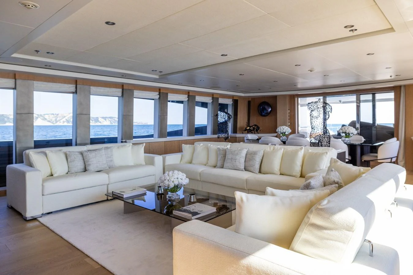 The spacious salon features plush seating and panoramic windows offering stunning ocean views. aboard FIVE Yacht for Sale