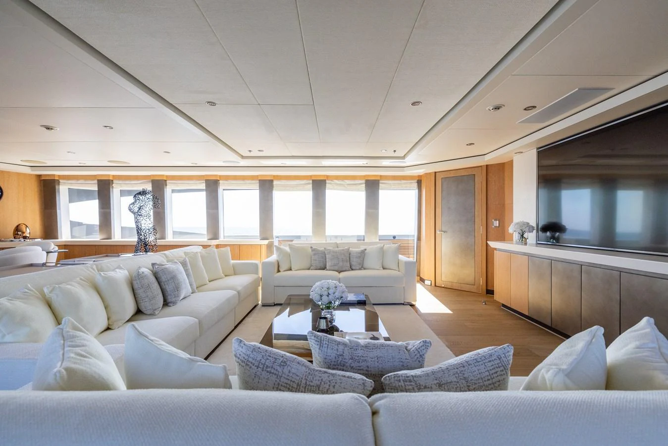 The salon features luxurious seating with ample natural light and modern decor. aboard FIVE Yacht for Sale