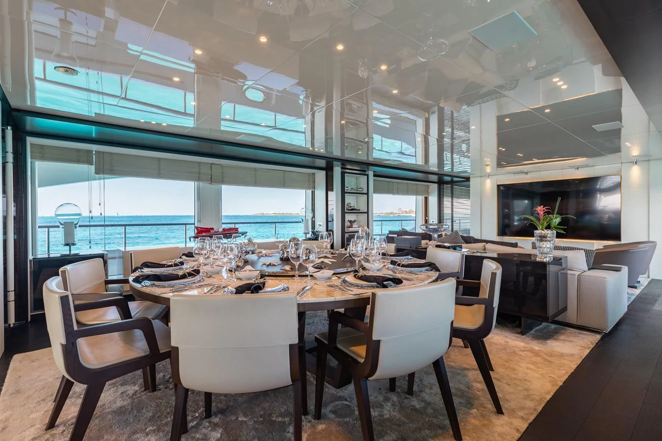 The yacht's dining area offers a luxurious setting with a stunning ocean view. aboard DOMANI Yacht for Sale
