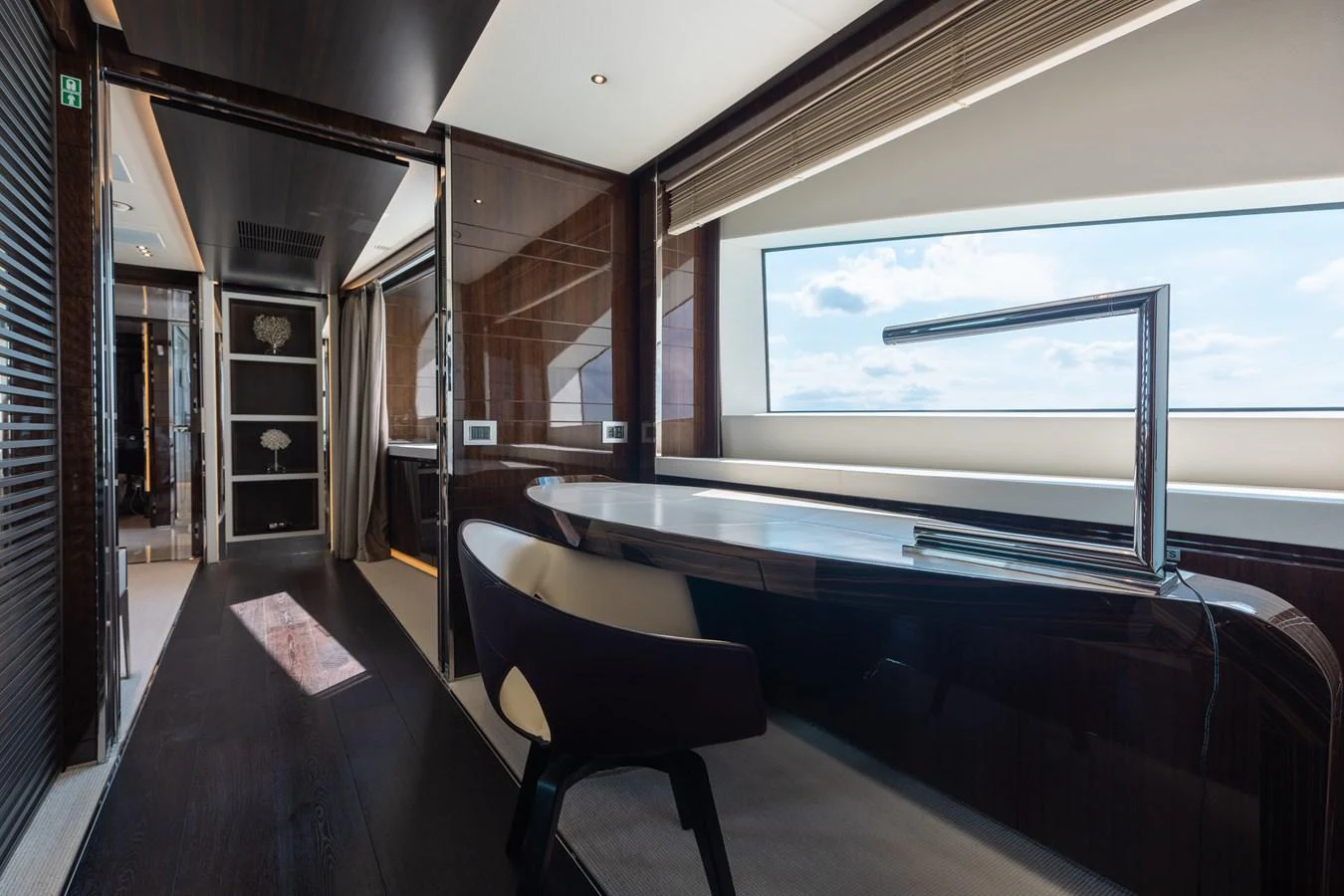 A sleek and modern interior space with a large window offering a stunning view of the sea. aboard DOMANI Yacht for Sale
