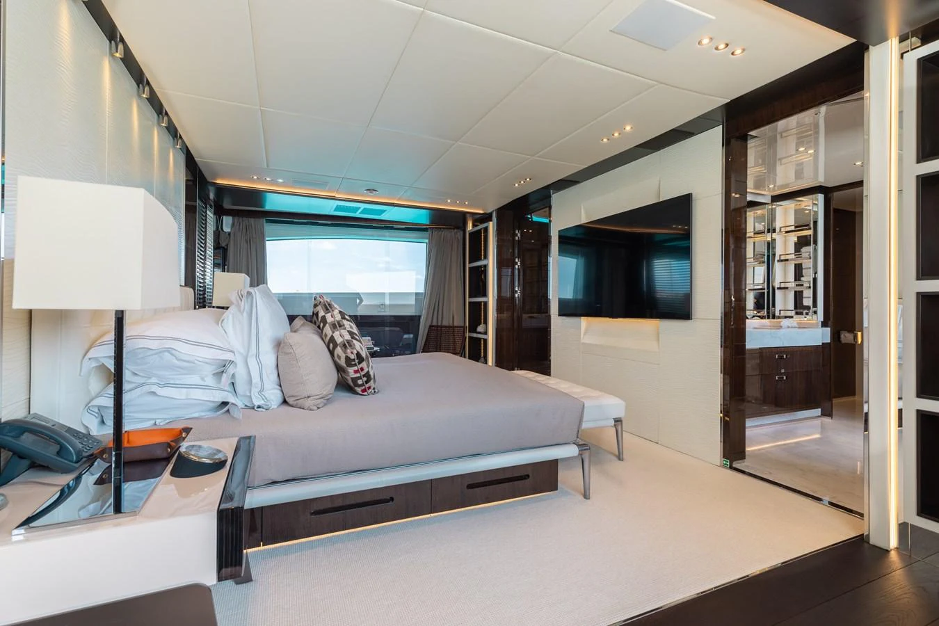 The master stateroom features a luxurious bed, modern decor, and ample natural light. aboard DOMANI Yacht for Sale