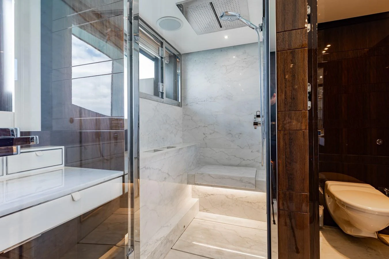 The yacht's bathroom features a luxurious marble shower and modern fixtures. aboard DOMANI Yacht for Sale