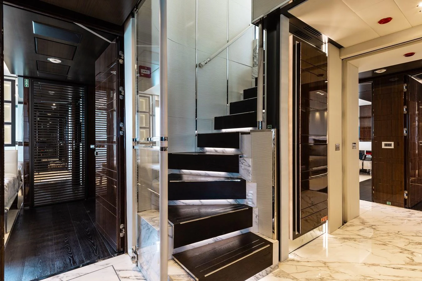 The image showcases a luxurious interior staircase with modern design elements and high-end finishes. aboard DOMANI Yacht for Sale
