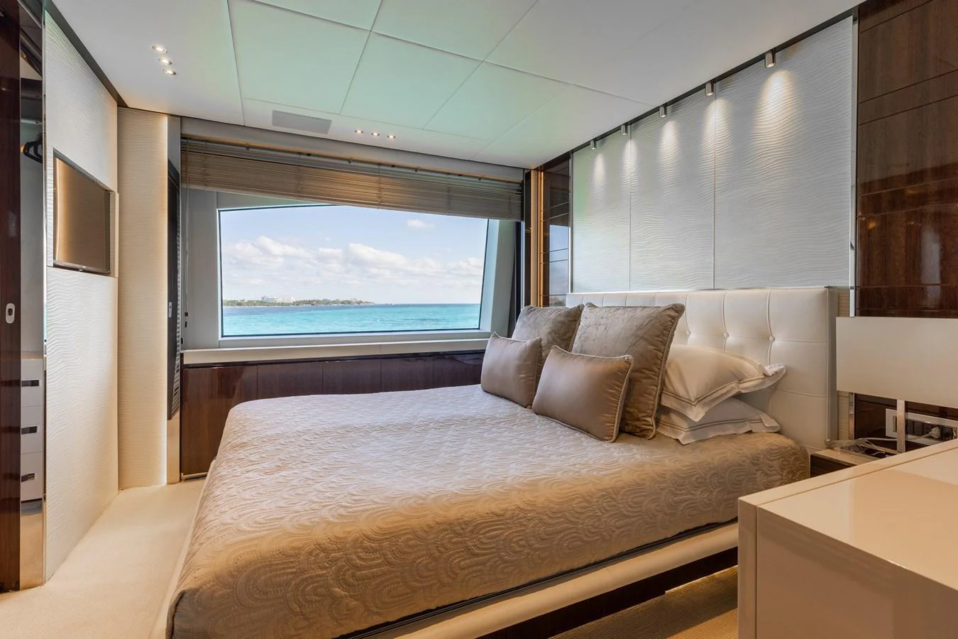 A luxurious stateroom with a large window offering a stunning ocean view. aboard DOMANI Yacht for Sale