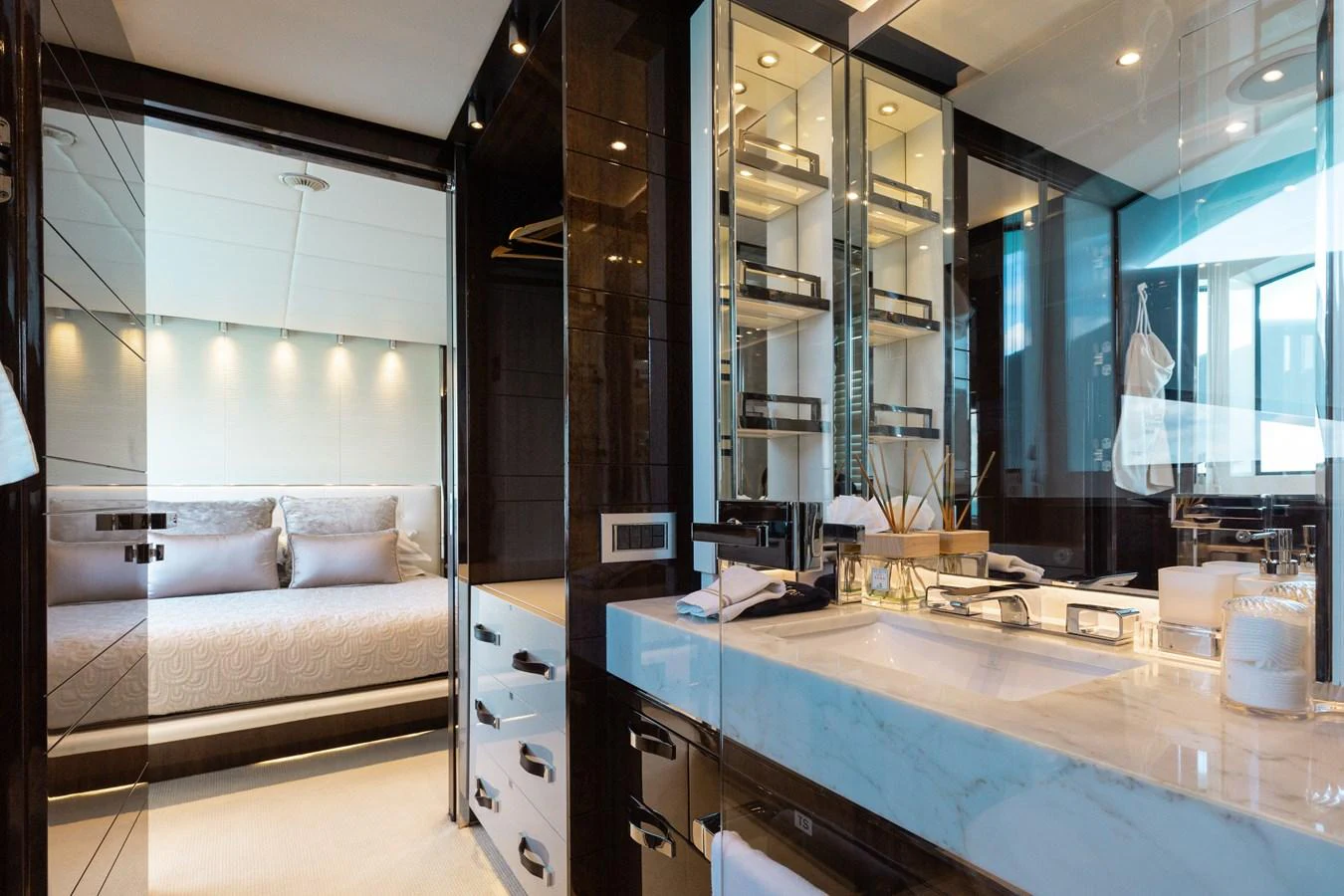 The luxurious bathroom features a sleek design with a view into the adjacent bedroom. aboard DOMANI Yacht for Sale