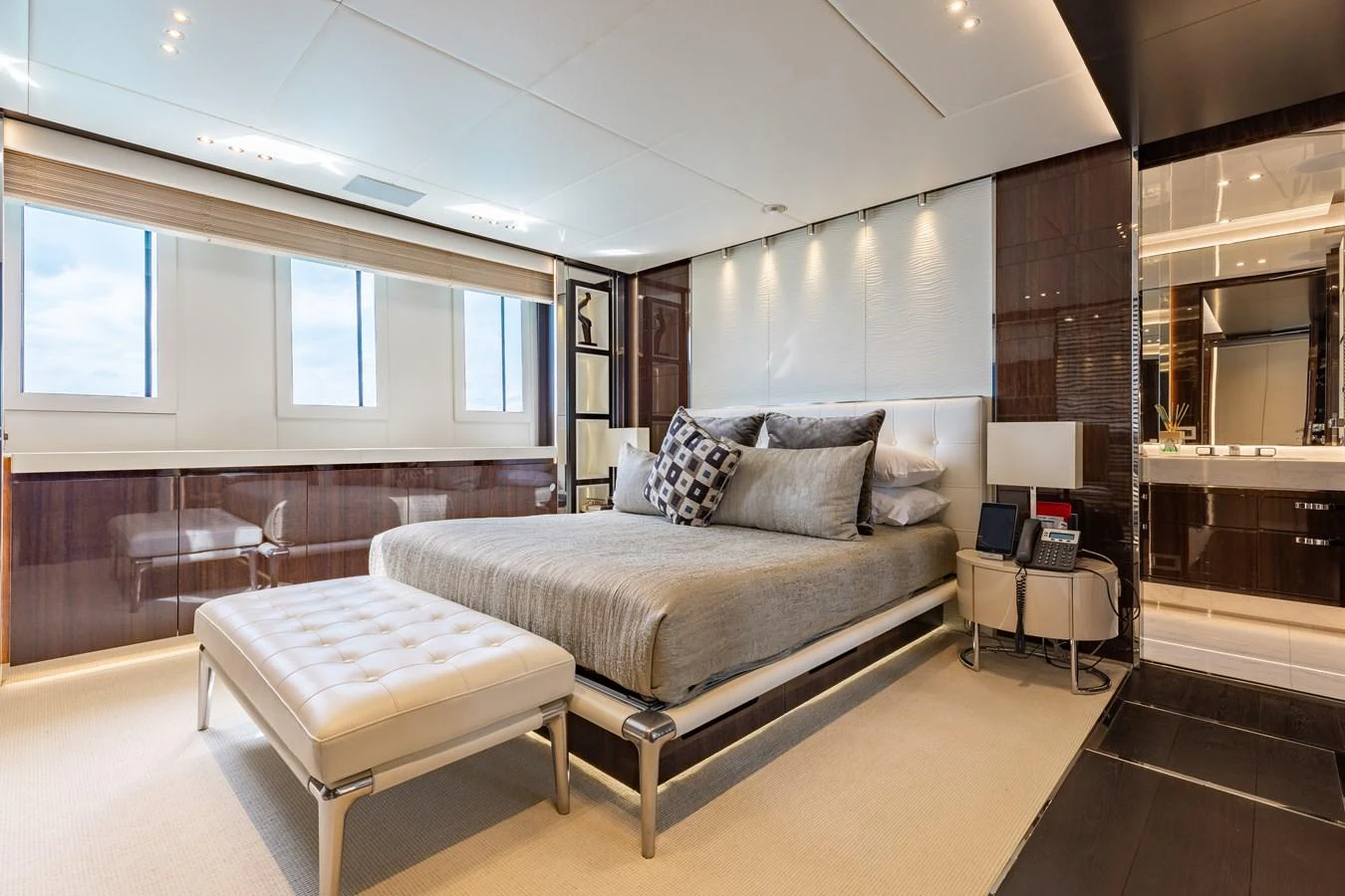 The master stateroom features a luxurious bed with elegant furnishings and ample natural light. aboard DOMANI Yacht for Sale