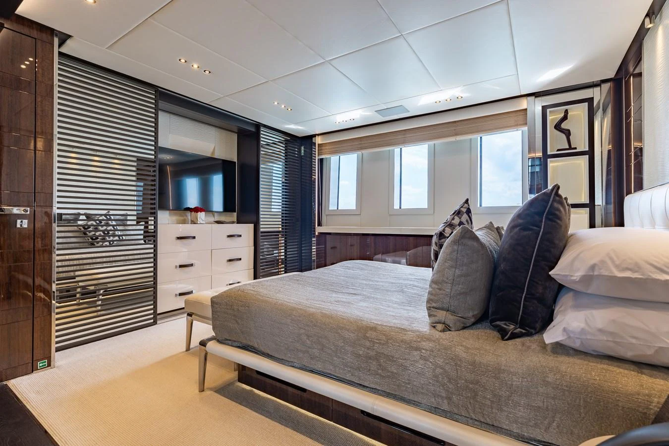 The stateroom features a luxurious bed with elegant decor and ample natural light. aboard DOMANI Yacht for Sale