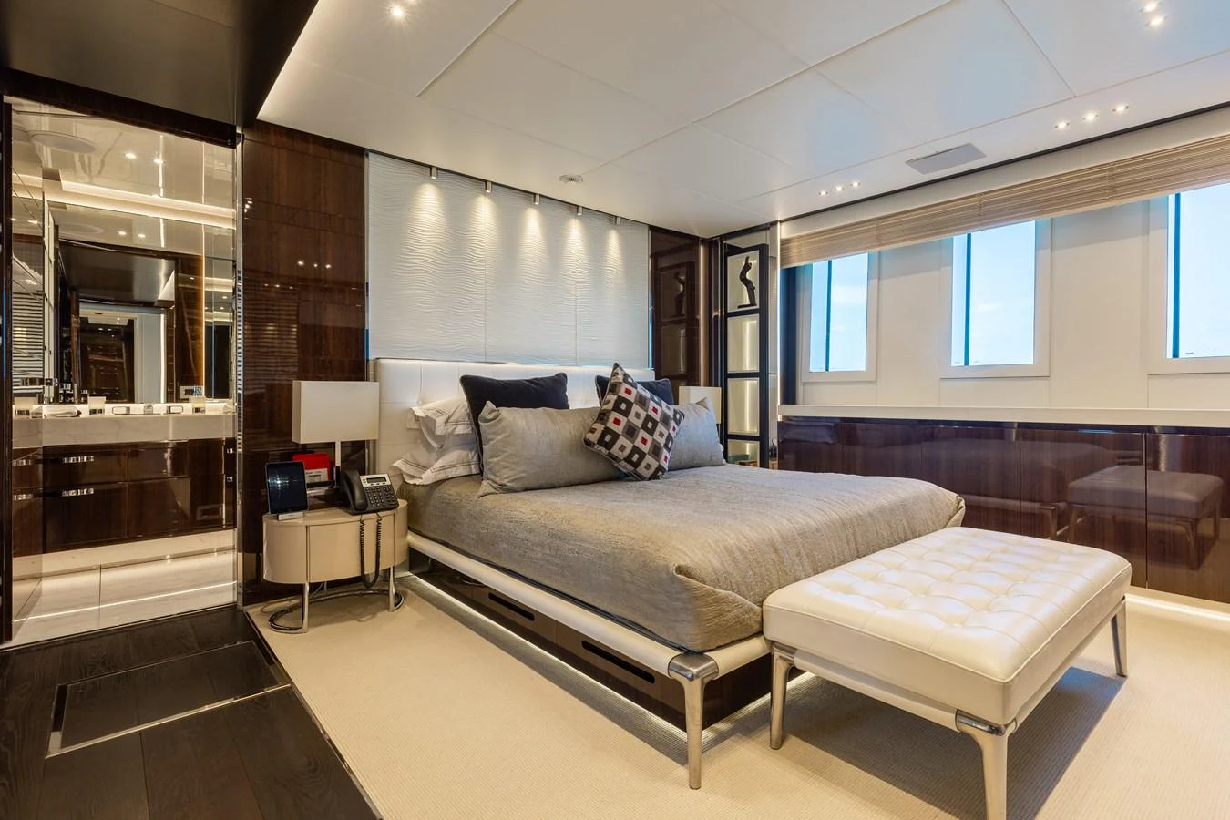 The master stateroom features a luxurious bed, modern furnishings, and ample natural light. aboard DOMANI Yacht for Sale