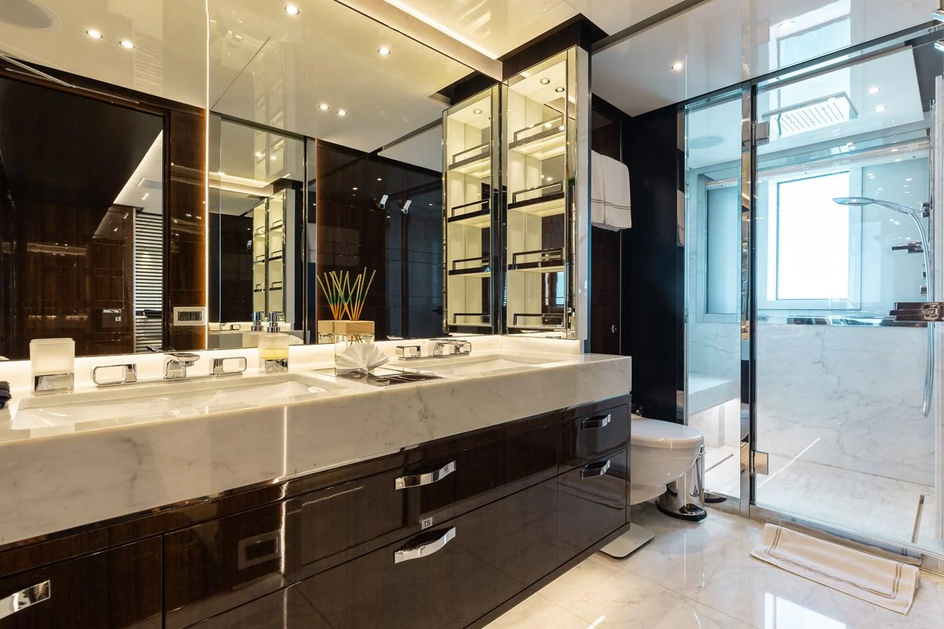 The yacht's bathroom features a luxurious double vanity and a spacious shower area with elegant finishes. aboard DOMANI Yacht for Sale