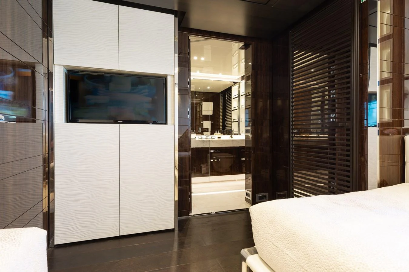 The stateroom features a modern design with a view into the en-suite bathroom. aboard DOMANI Yacht for Sale