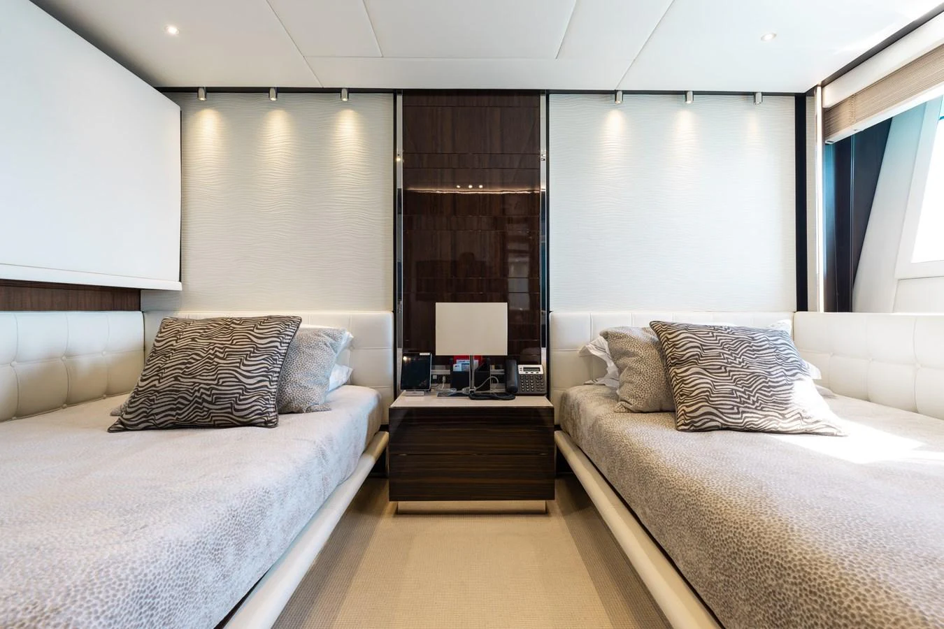 A luxurious twin stateroom featuring modern decor and comfortable bedding. aboard DOMANI Yacht for Sale