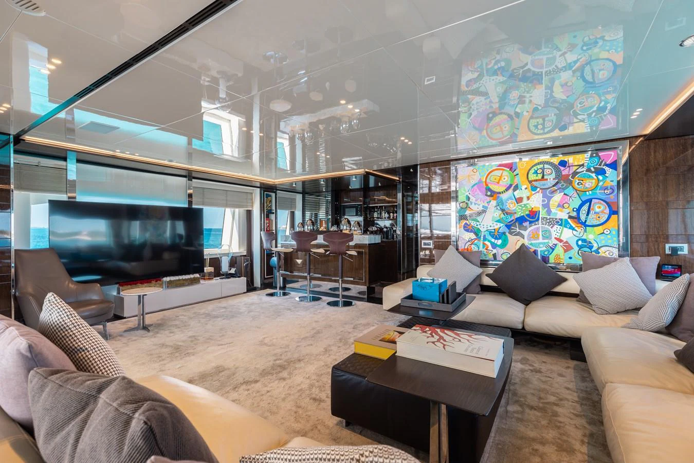 The salon features a contemporary design with plush seating and vibrant artwork, creating a luxurious and inviting atmosphere. aboard DOMANI Yacht for Sale
