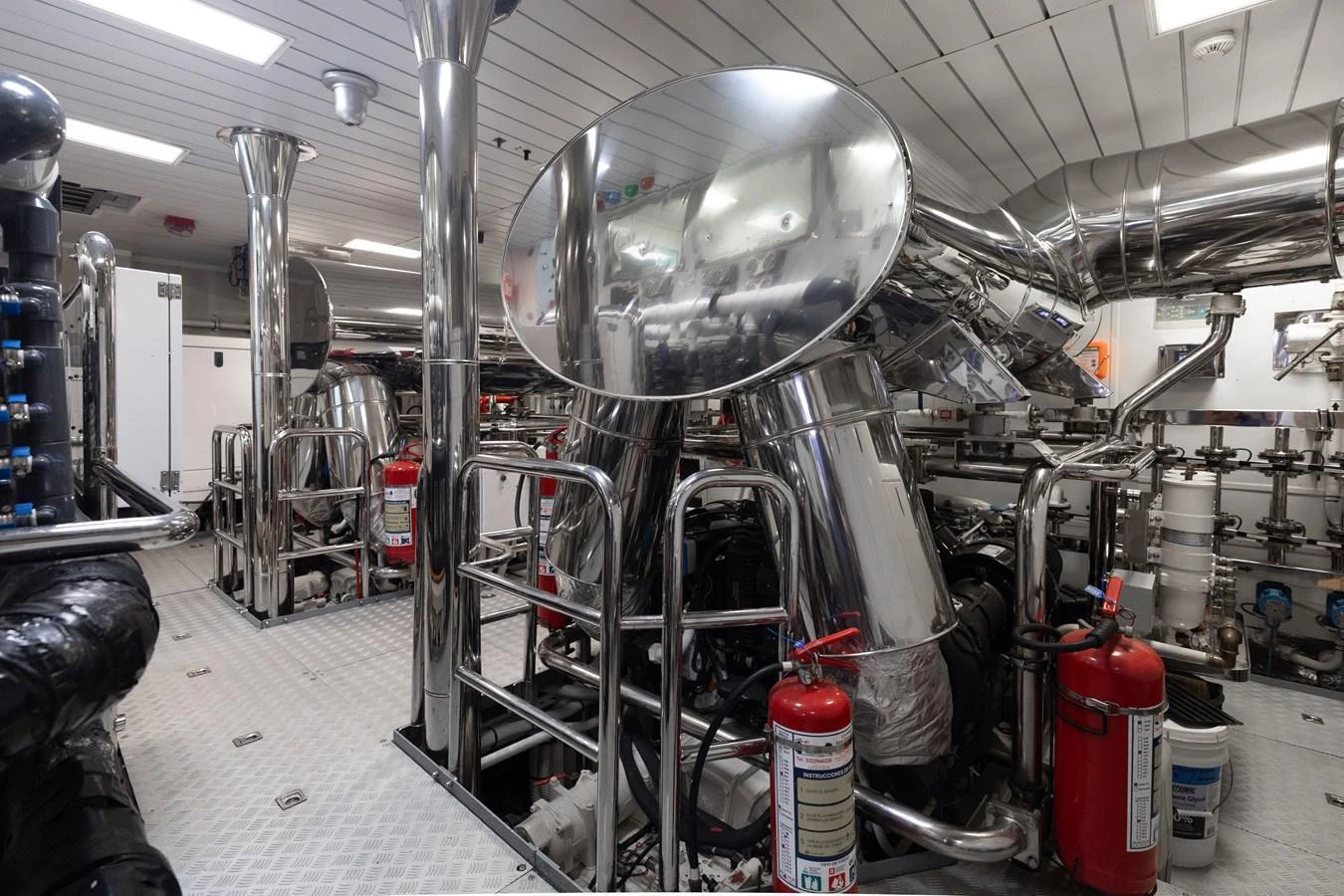 The image showcases the yacht's engine room with gleaming metallic surfaces and essential safety equipment. aboard DOMANI Yacht for Sale