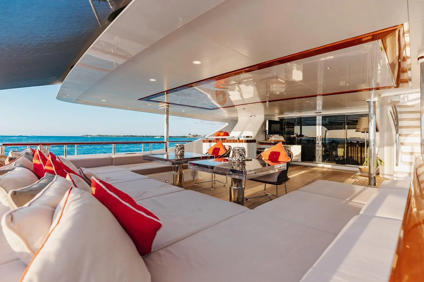 The aft deck offers a spacious and luxurious lounging area with plush seating and vibrant accents, perfect for relaxation and entertainment. aboard DOMANI Yacht for Sale