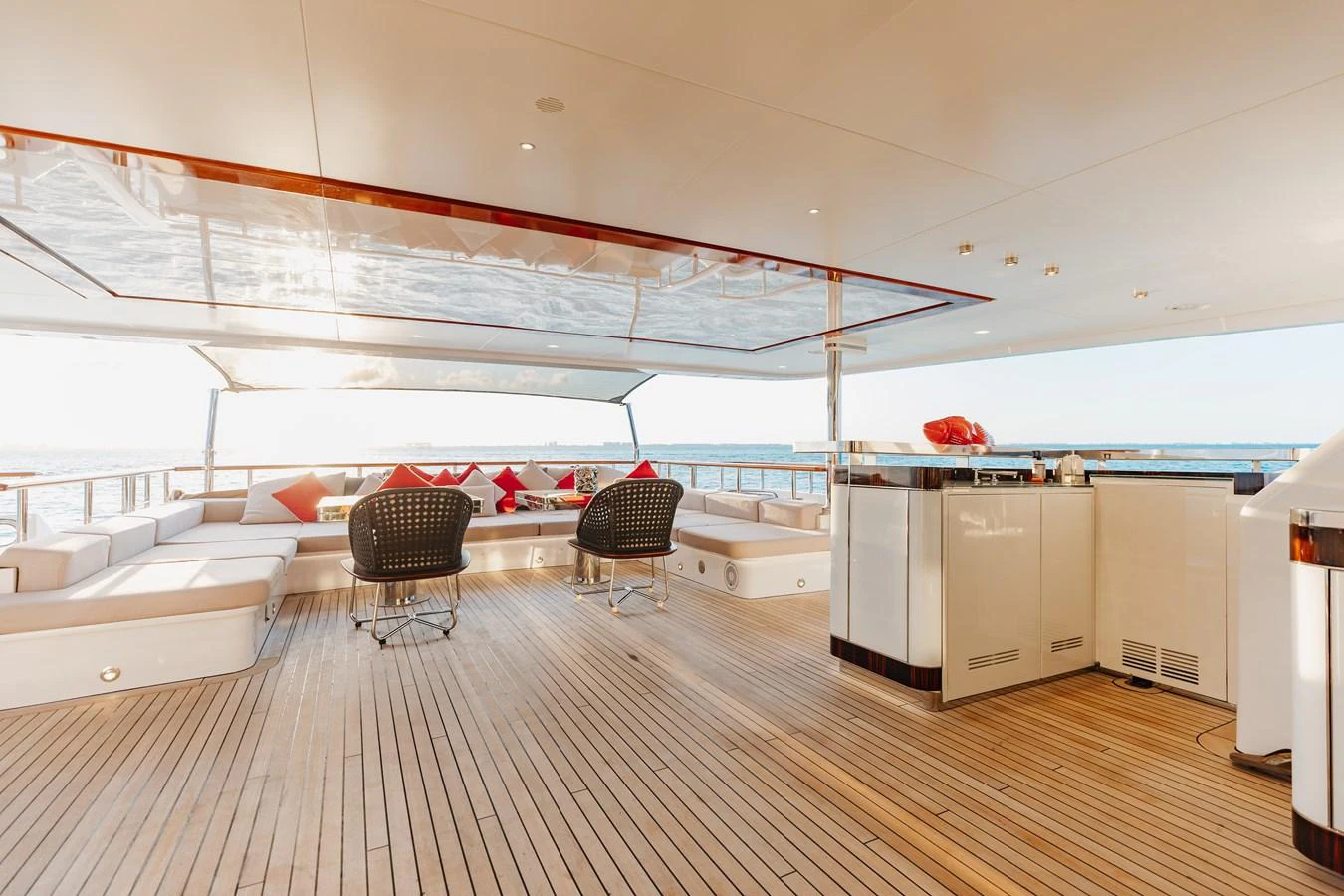 The aft deck offers a spacious and inviting area with comfortable seating and a bar, perfect for relaxation and socializing. aboard DOMANI Yacht for Sale