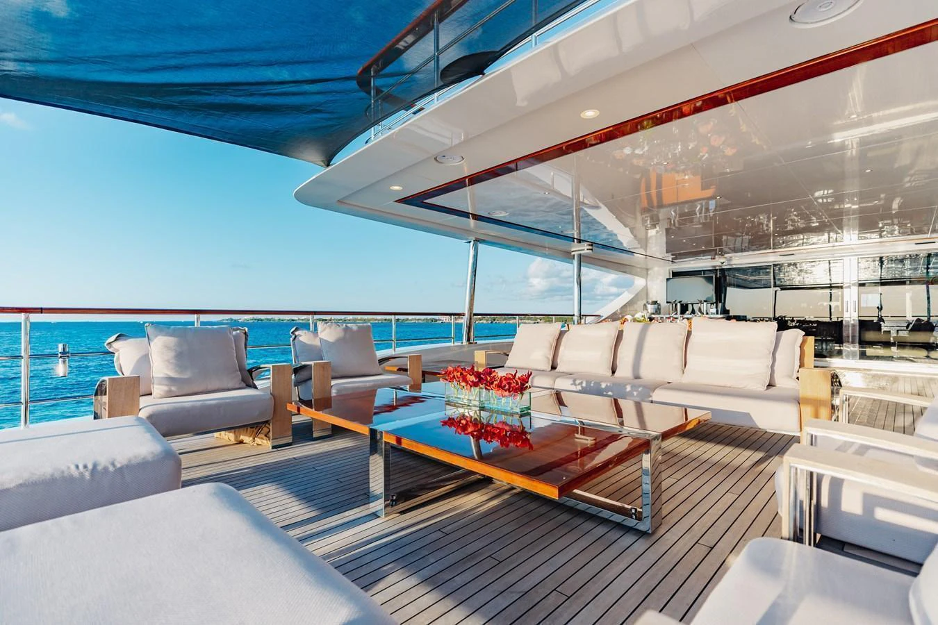 The aft deck offers a luxurious outdoor seating area with plush sofas and a stylish coffee table, perfect for relaxation and entertaining. aboard DOMANI Yacht for Sale