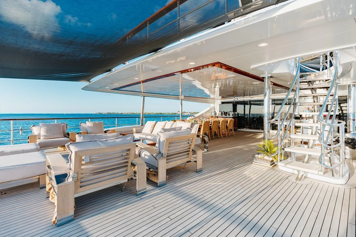 The aft deck offers a spacious and luxurious outdoor lounging and dining area with stunning ocean views. aboard DOMANI Yacht for Sale