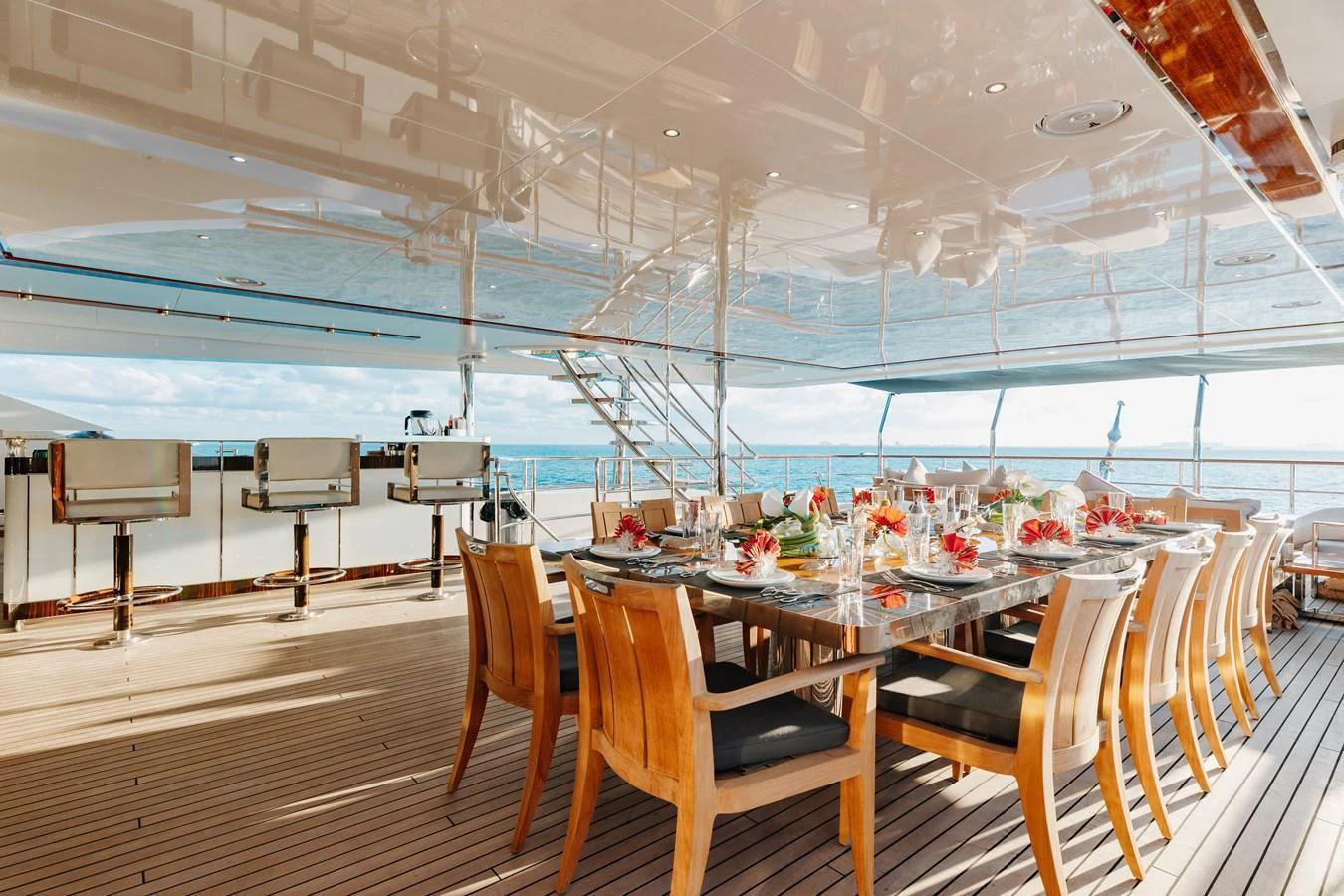 The aft deck features an elegant dining area with a large table and comfortable chairs, perfect for alfresco meals. aboard DOMANI Yacht for Sale