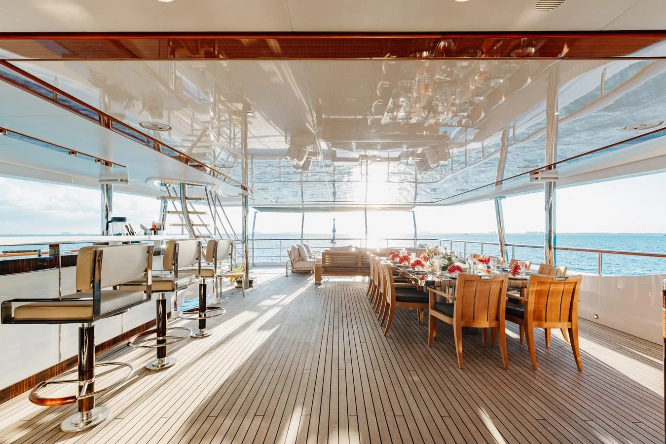 The aft deck offers a luxurious dining and bar area with stunning ocean views. aboard DOMANI Yacht for Sale