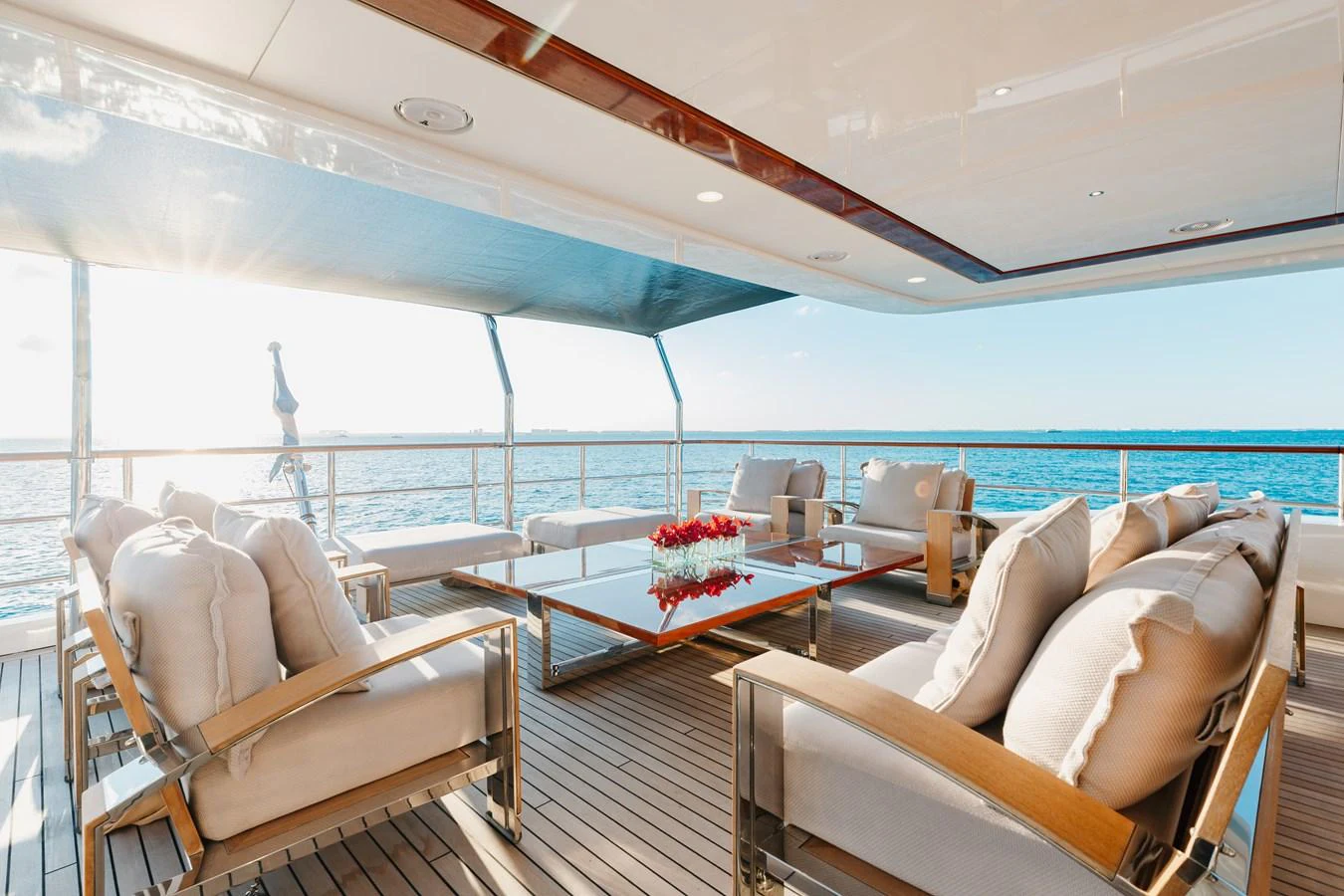 The aft deck offers a luxurious outdoor seating area with plush cushions and a stunning ocean view. aboard DOMANI Yacht for Sale