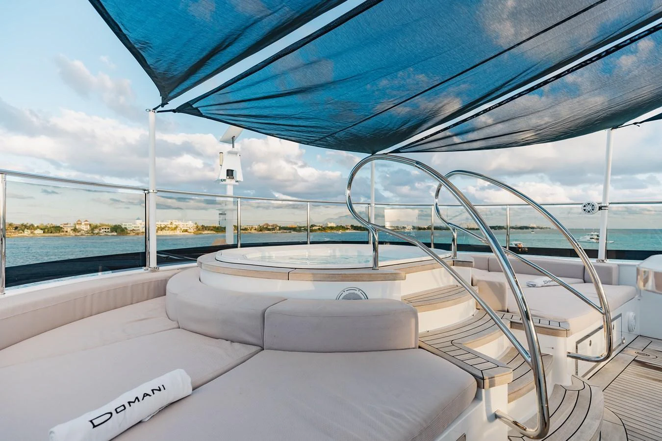The sundeck features a luxurious jacuzzi surrounded by comfortable seating and shaded by a sleek canopy. aboard DOMANI Yacht for Sale