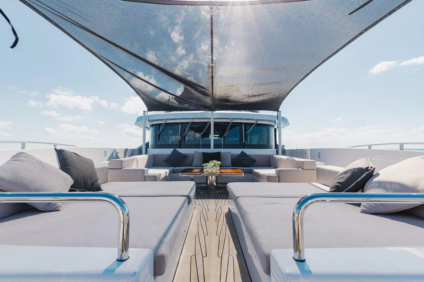 The sundeck features luxurious lounging areas under a stylish shade canopy, perfect for relaxation. aboard DOMANI Yacht for Sale