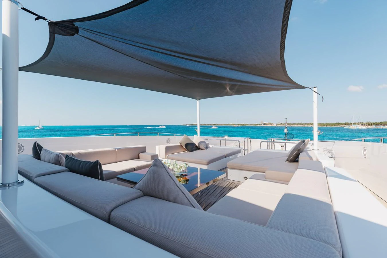 The sundeck offers a spacious and comfortable lounging area with a shade canopy, perfect for relaxation and enjoying the sea views. aboard DOMANI Yacht for Sale