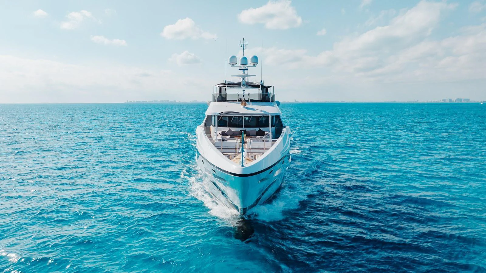 A luxurious yacht cruises through pristine blue waters under a clear sky. aboard DOMANI Yacht for Sale