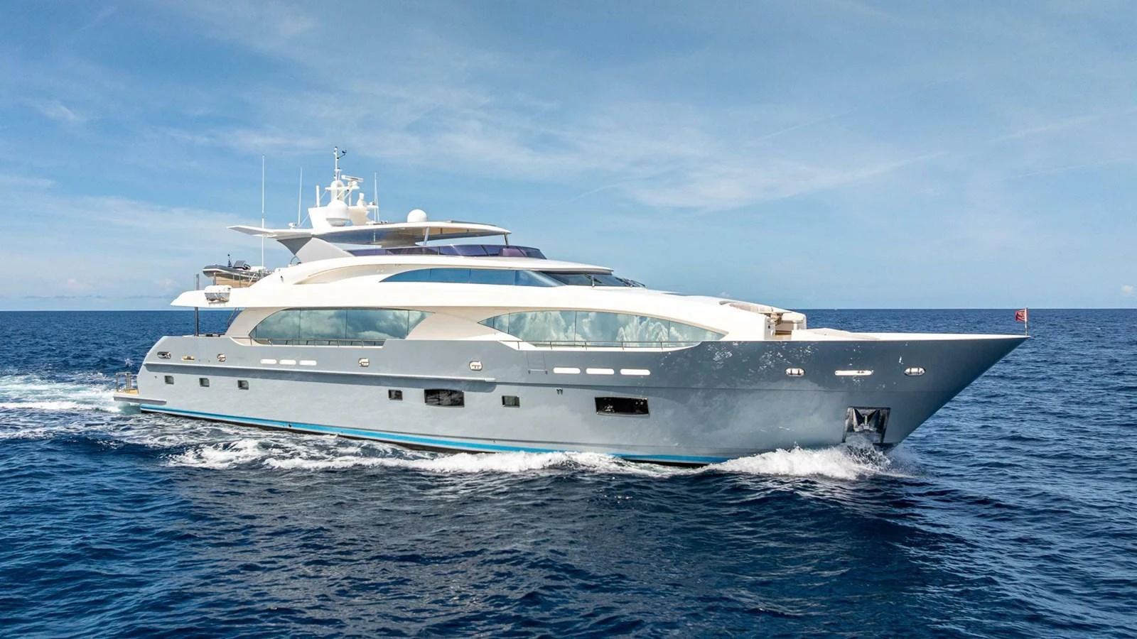 A sleek and modern yacht cruising on open waters under a clear blue sky. aboard SHORT STORY Yacht for Sale