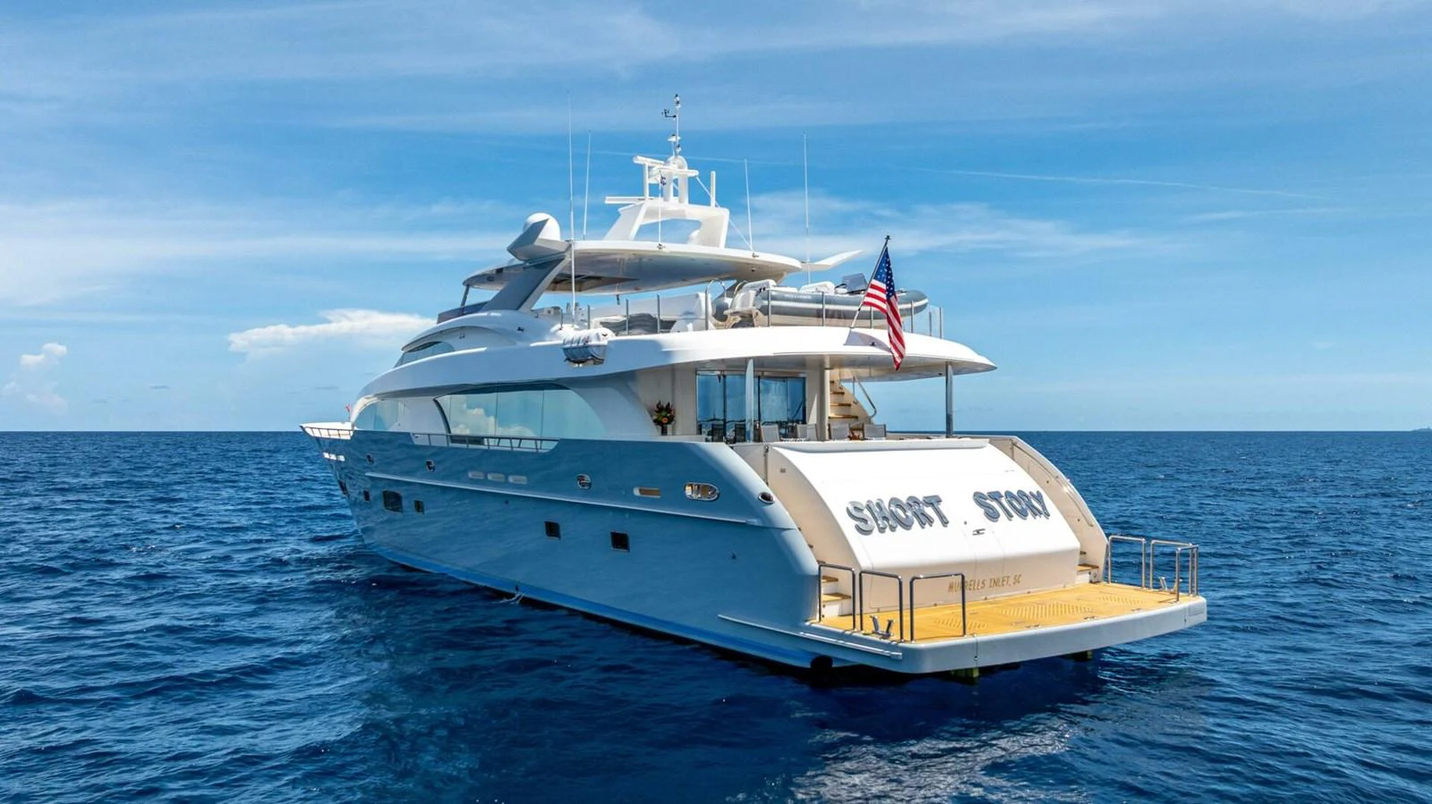 A luxurious yacht sails on the open sea under a clear blue sky. aboard SHORT STORY Yacht for Sale