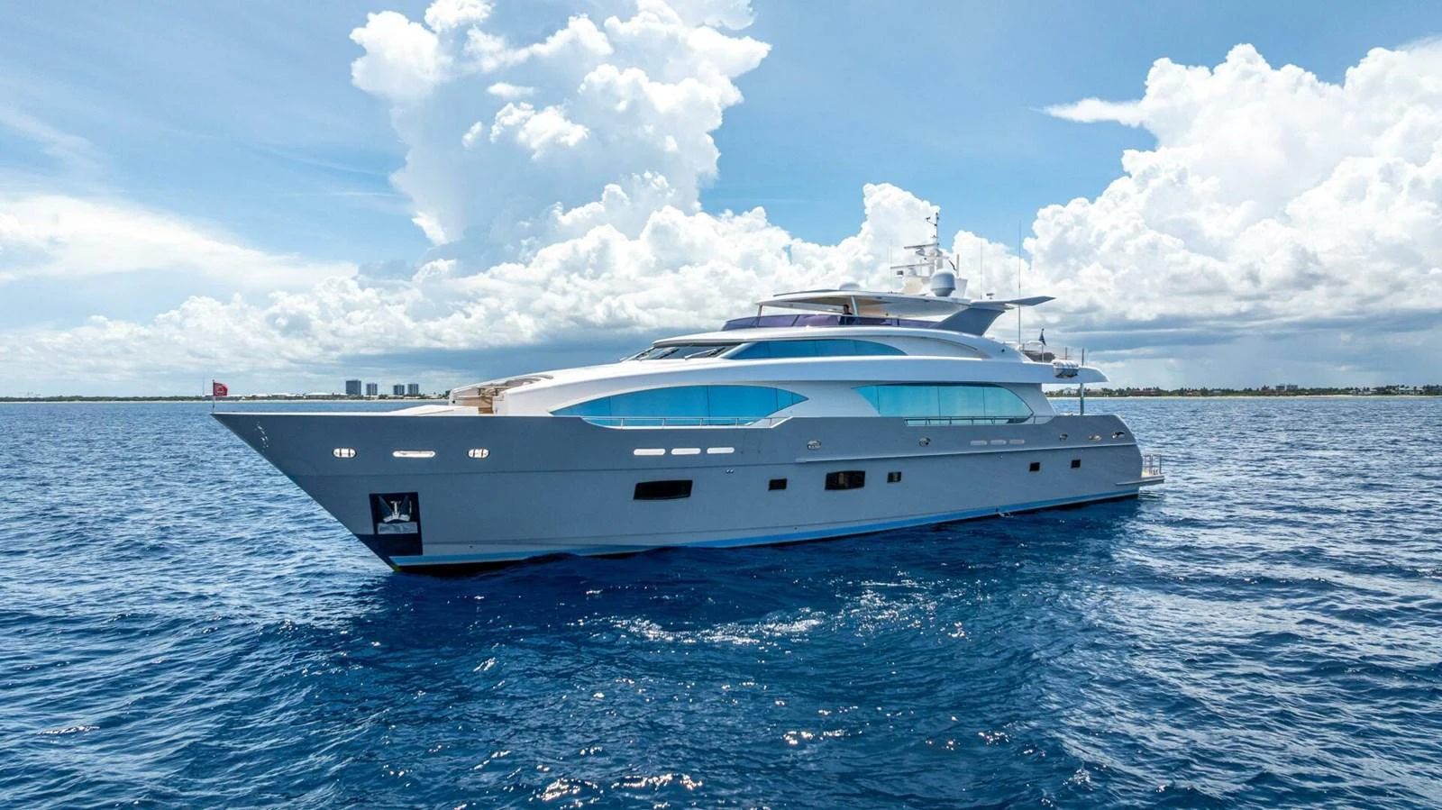 A sleek and modern yacht glides gracefully on the open water under a bright blue sky. aboard SHORT STORY Yacht for Sale