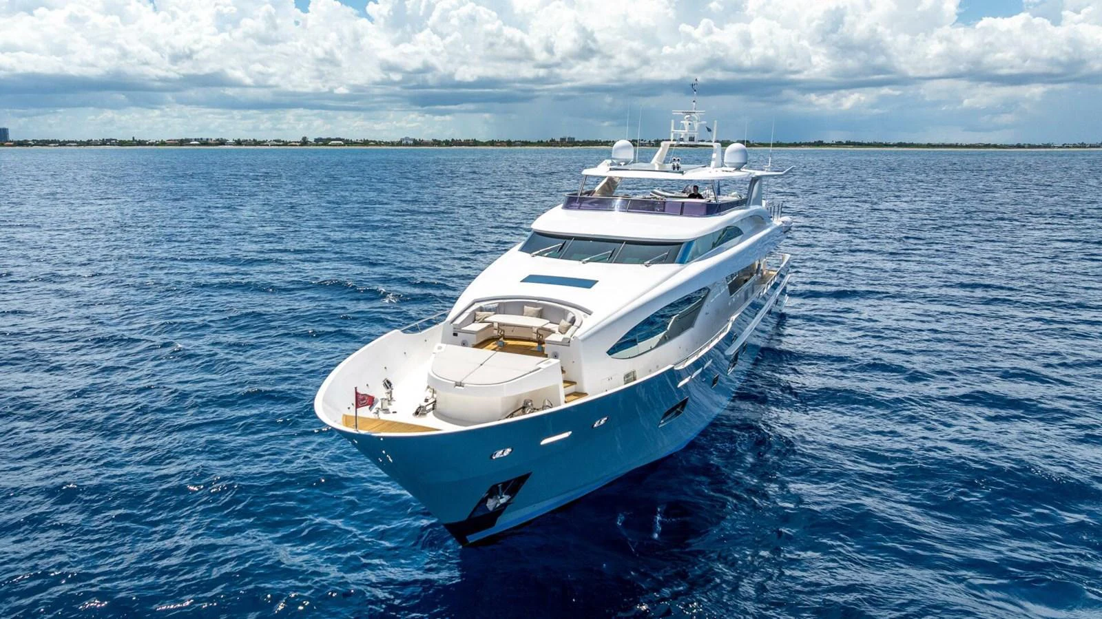 A luxurious yacht glides gracefully on the open sea under a bright, clear sky. aboard SHORT STORY Yacht for Sale
