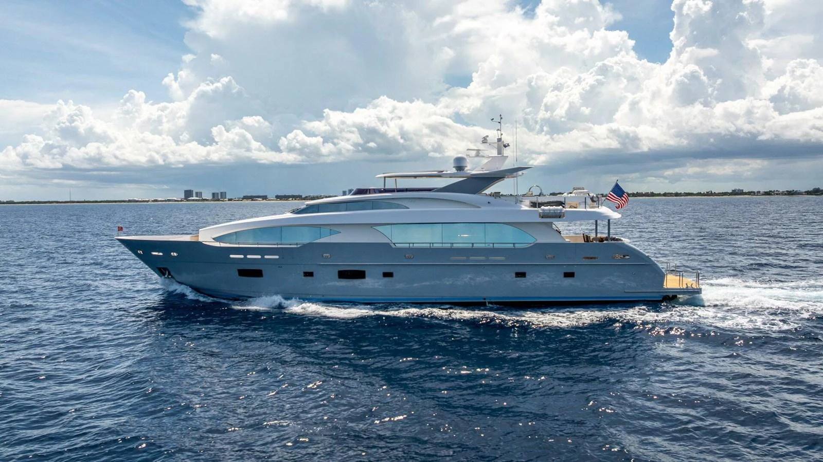A sleek and modern yacht cruising on a calm sea under a partly cloudy sky. aboard SHORT STORY Yacht for Sale