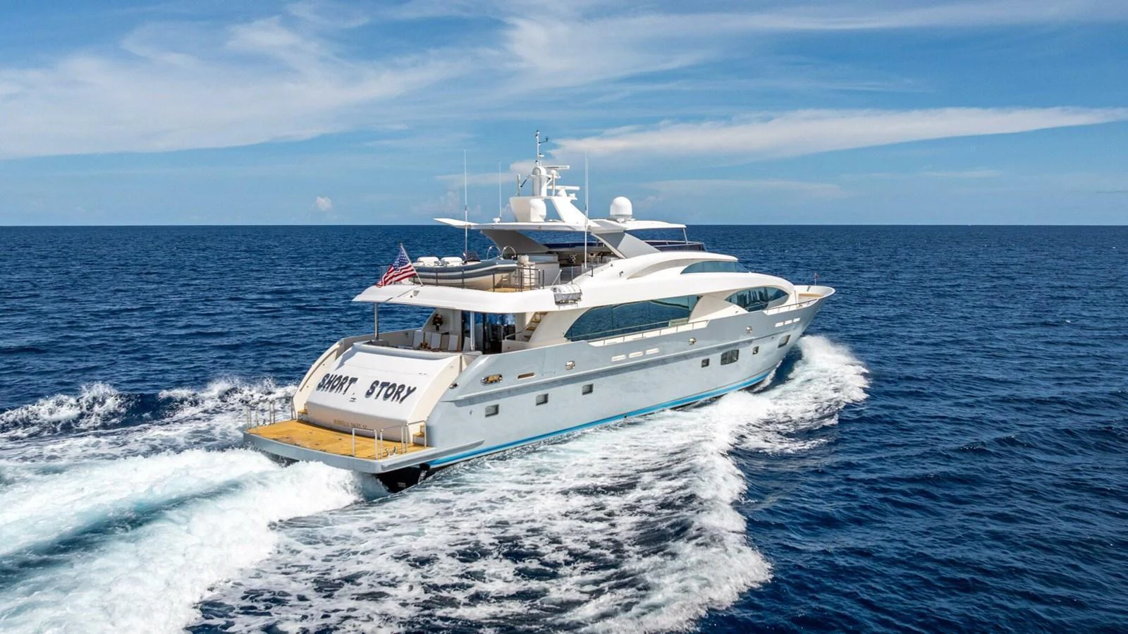 A luxurious yacht cruises through the open sea under a clear blue sky. aboard SHORT STORY Yacht for Sale