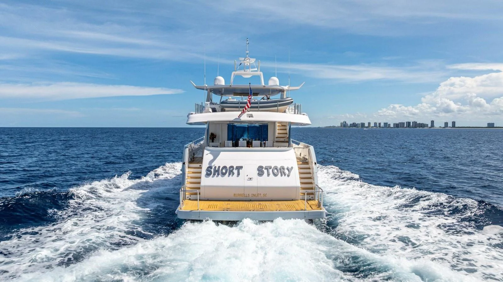 A luxurious yacht cruises through the open sea, leaving a trail of white foam in its wake. aboard SHORT STORY Yacht for Sale