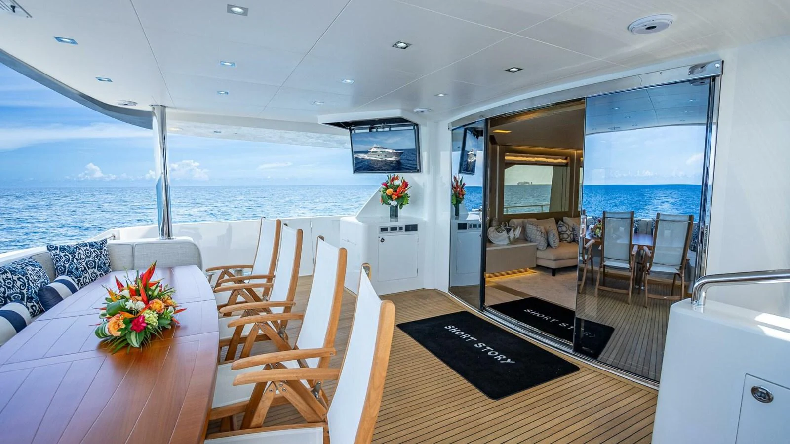 The aft deck features a spacious dining area with a seamless transition to the interior living space. aboard SHORT STORY Yacht for Sale