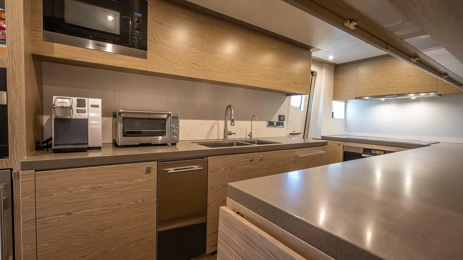 The yacht's galley features modern appliances and sleek wooden cabinetry, offering a functional and stylish cooking space. aboard SHORT STORY Yacht for Sale